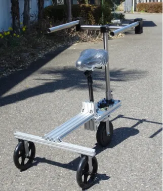 図 5   後輪操舵 PMV 試作外観   ３．２  走行アシスト  駆動輪は、インホイールモータであり、車輪内にブラシ レス DC モータが組み込まれ、ホール素子を用いて回転 を検出している。駆動系はマイクロコントローラ、モー タドライバ、バッテリで構成される。図 6 に走行アシ スト装置の構成を示す。 図 6   走行アシスト装置の構成 制御プログラムは、運転者がメインスイッチを ON 状 態で路面を蹴り出したとき、後輪のホールセンサで検出したパルスをArduino互換マイクロコントローラでカウントし、