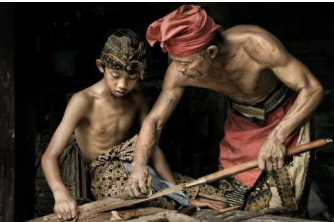 Figure 3.3:  A picture of the present time of a master (The Pande) and a young apprentice are making  a traditional Balinese spear (circa 2000s)