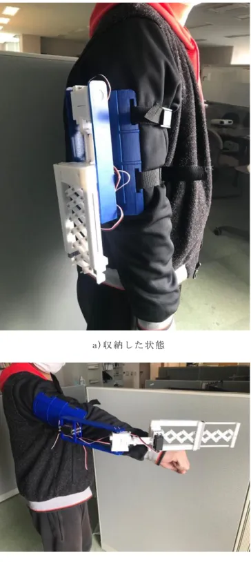 図 5： 実 際 に 装 着 す る 様 子図3： 伸 縮 機 構 の3Dモ デ ル図4： ３Dプ リ ン ト し た パ ー ツ の 詳 細 写 真 a)伸 縮 機 構 の 写 真 （ 補 強 カ バ ー 有 り ） b)デ バ イ ス の 全 体 像a)収 納 し た 状 態 b)展 開 し た 状 態 