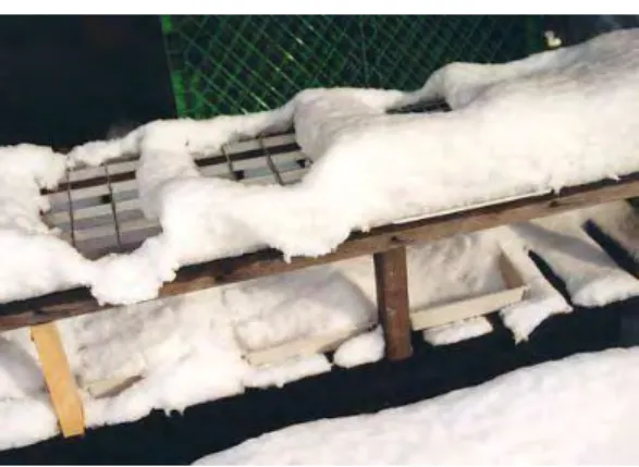 図 2-12  格子から雪が抜け落ちている様子  於栃尾市原町  H12.2.2  （２）7.5cm 角の鉄板格子とアルミ板格子の場合    まとまった雪が降らず、上記図 2-8〜12 のような結果が続いたため、平成 12 年 2 月に 1 区画を奥行 45cm×幅 60cm×高さ 100cm の単管パイプの枠を作り、その上に 7.5cm 角の 鉄板とアルミ板の格子を固定した。次に、庭のざらめ雪をその上に 100cm 積み上げ、その 融雪と出水の過程を観察した。      図 2-13  実験装置の様子（北