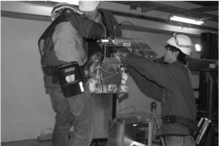 図 15: LHCf 検出器のインストール作業風景。外国人共 同研究者や CERN スタッフの中で日本の大学院生も活躍 している。 ル運転を開始した日本の TA 実験による独立な観測結果 に期待がかかっている。上記宇宙物理的な未知数と並んで データの解釈に影響を与えるのが, 宇宙線と地球大気のハ ド ロン相互作用モデルである。この不定性を抑える唯一 で最良の方法は LHC 加速器を用いることであり, LHCf 実験は LHC IP1 において, 宇宙線空気シャワー発達に重 要な最前方放出粒子の測定を行なう。