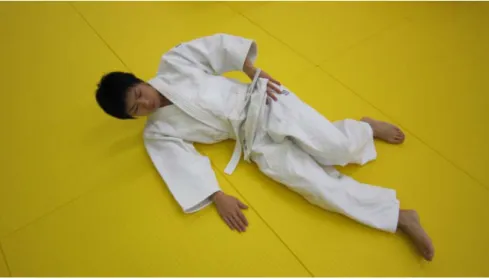 図 1.後ろ受身におけるフィニッシュの姿勢  2．動画 7  新たな後ろ受身の指導後、投げ込みを行った。その結果、取の片方の手によって、受の片方の手は握 られていてもスムーズに後ろ受身を行っている様子が窺えた。  Ⅴ．まとめと今後の課題  従来の後ろ受身の指導方法である段階的指導法  (基本編)  は従来の指導書にも多く記され、畳を打 つタイミングや後頭部を保護するための姿勢を身に付けるために、大変重要な基本技能である。しかしな がら、初心者レベル授業の自由練習  (乱取)  においても、「大外刈」、「大内