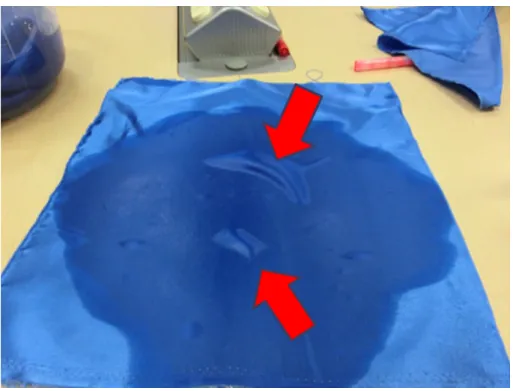 図 1.3: 気泡の発生 が布の表面から裏面にかけて凹んでいることが分かる．これは布が濡れているこ とで内部に空気が入ることができず，内部と生じた気圧差によって引き上げた箇 所に布を押し付けるような力が加わったためである． その他にも布の表面での反射が大きくなりテカリが出る，布の色が暗くなると いった外観の変化も起きている．色の変化としては白い布のような色の隠蔽力が 低い布である場合，布の下の色が透けて見えるという現象も起きる． このような布が濡れることに着目をした研究としては，Huber ら [20] の