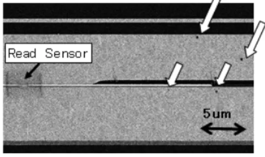 図 1　放電痕の SEM 写真（白抜き矢印）