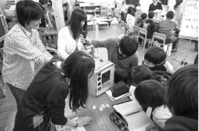 図 24  小学校での発表会の様子 2） 科学館での展示会  連携をしているかわさき宙と緑の科学館にて，2014 年度よ り展示会を実施している（図 25） ．かわさき宙と緑の科学館 は，生田緑地の敷地内に建てられており，近くには多摩川が 流れているなど，地域資源であるフィールドと学びを繋ぐ実 践の場として非常に優れた環境である．展示会では，小学校 訪問による発表会で気付きを得た課題点の改善に加え，ター ゲットユーザとして設定した学年だけでなく幅広い年齢層の 人々が体験できるように調整した学習教材とシナリオ