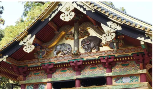 図 29  日光東照宮上神庫    そこには、狩野探幽 36 の原図によるといわれる 2 頭の象のレリーフ(図 30)がある。右側の象は三日月 形をした目、独特の表情や耳を結わえた金の金具が特徴的である。 左の象は体毛がマンモスのように フサフサとして、尻尾が枝分かれているようにも見える。こうした姿は、現実の象の姿を知る我々にと っては“不思議な象”として映り、より神秘的な姿に感じられる。実はこの象は、象を見た事がない人々 が想像で描いた“想像の象”の図案を引いている。  図30  図 29 拡大図    