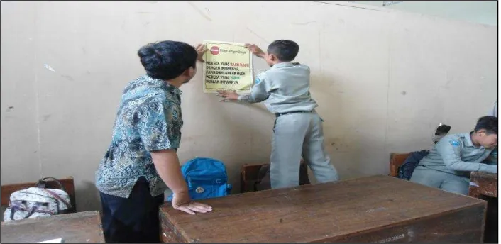 Figure 5. Sticking Motivational Posters on the Wall by Involving the Students 