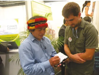 Fig. 4.3 Tito Puanchir of the Confederation of Indigenous Nationalities of the Ecuadorian  Amazon being interviewed by Matthew Tegelberg in the NGO tent