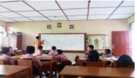 Gambar 5. Guru Menjelaskan Petunjuk Kegiatan yang  akan Dilakukan oleh Siswa dan Mempertegas Masalah yang Tersaji dalam LKS dengan Menuliskan di Papan Tulis 
