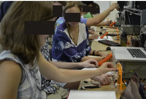 Figure 2.5: Small teams of 2-3 students interacting with the haptic paddle during a lab activity.