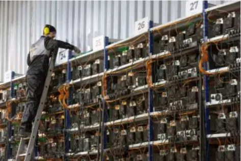 Gambar 2 . An engineer inspects racks of mining devices at a  Cryptocurrency mining farm in Norilsk, Russia (2022) 