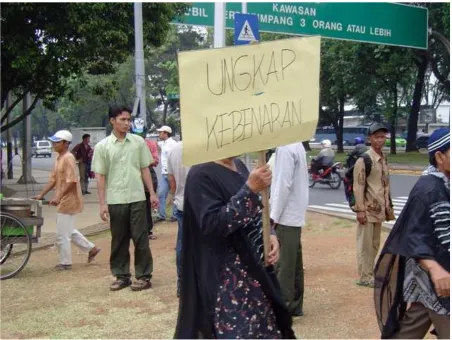 Figure 2: Eks-tapol demonstrating outside of the Presidential Palace in Jakarta. Her sign reads "Reveal the Truth" Photo by the author