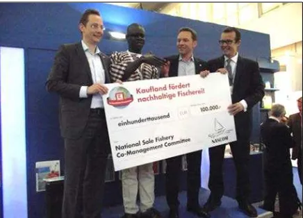 Figure 13. German retailer Kaufland handing over € 100,000 donation to NASCOM Secretary  Dawda Saine at the MSC booth at European Seafood Exposition in April 2013 in Brussels