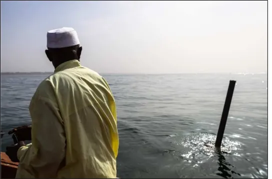 Figure  4.  Ousman Bojang of NASCOM deploying the spar buoy.        (photo credit:  MSC)  