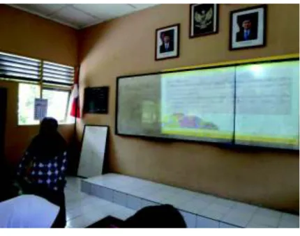 Gambar  7.  Guru  sedang  Menjelaskan  Langkah-Langkah  Diskusi  Siswa  yang Sudah Tertera Pada Media Presentasi PowerPoint 