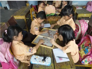 Gambar 1. Siswa sedang menempatkan kacang merah pada wadah bernilai puluhan-satuan 