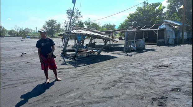 Gambar 1. Nengah Regig saat menunjukan warung milik kerabatnya yang rusak diterjang ombak  tinggi di pesisir Karangdadi, Desa Kusamba, Rabu (26/5/2021) (sumber : bali.tribunnews.com) 