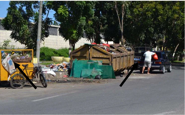 Gambar 28 :  Kenek truk menurunkan sampah dalam karung plastik yang sudah dipilahnya dari gerobak sebelum sampah lainnya dipindahkan ke truk untuk diangkut ke TPA
