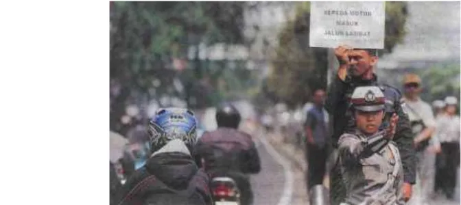 Gambar 12.6. Seorang polisi  lalu lintas sedang menjalankan tugas mengatur lalu lintassebagai salah satu bentuk pengendalian  sosial (Sumber : www.soe-geng.wordpress.com)