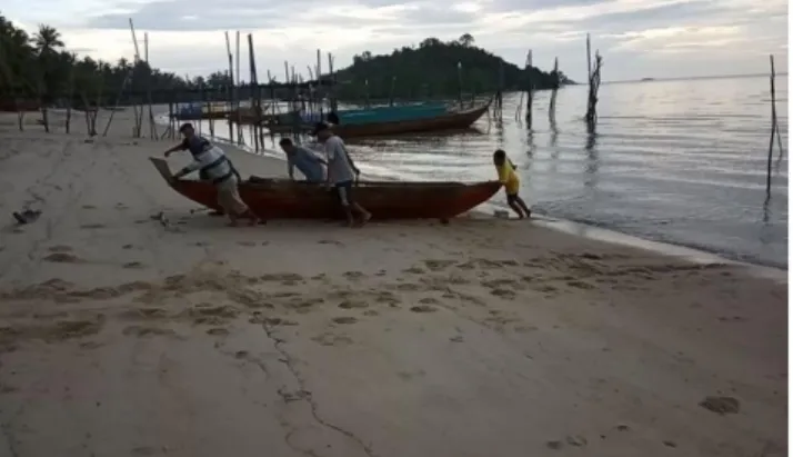 Gambar 3.2. Nelayan Pulau Tulang Bergotong Royong Menaikkan Perahu Ke Pantai. 