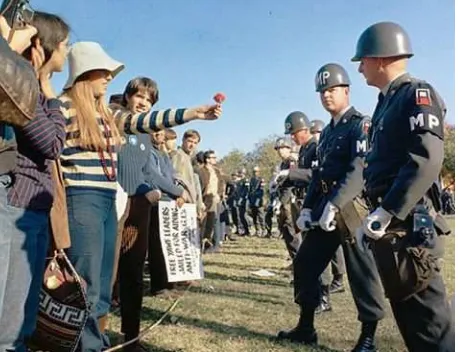 Gambar 00. Salah seorang demonstran kaum muda hippies memberikan sebatang bunga kepada seseorang tentara dalam barisan brikade