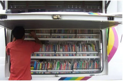 Gambar 3.1. Petugas perpustakaan keliling BPAD-SU sedang menata buku di dalam rak                         mobil perpustakaan keliling