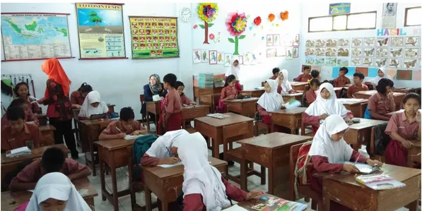 Gambar 10. Siswa Membaca dan Memahami Buku Cerita Bergambar Berbasis  Kearifan Lokal dengan Bimbingan Guru 