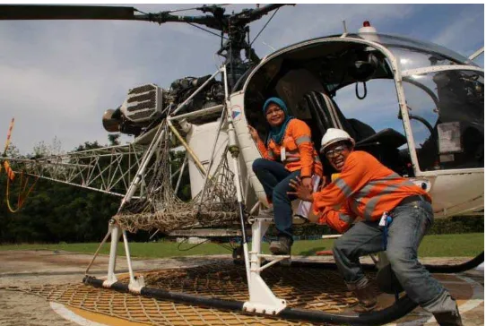 Gambar 5. Dua pekerja yang sedang berfoto dengan salah satu alat transportasi yang ada di PT Agincourt Resources Martabe