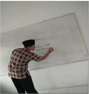 Gambar 1: Tim pengabdian mempraktekkan contoh menulis kaligrafi Arab di papan tulis. (Sumber;  Dokumentasi tim pengabdian) 