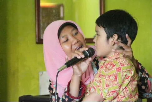 Gambar 9. Guru membimbing anak penyandang autisme untuk melakukan terapi bernyanyi (dok