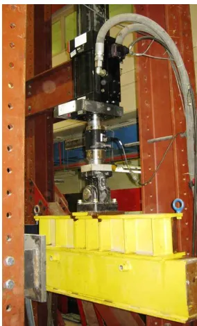 Figure 1. Spreader beam (in yellow) attached to a hydraulic actuator (in black and silver) 