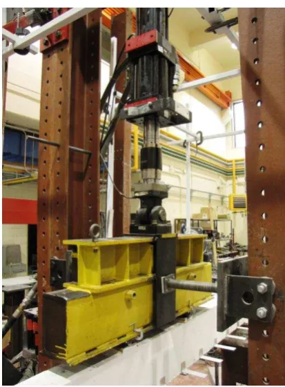 Figure 1. Spreader beam (in yellow) attached to a hydraulic actuator (in black and silver)  