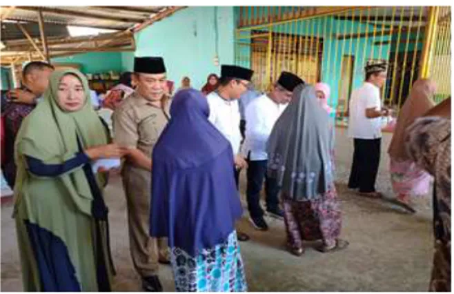 Gambar  1  :  Foto  Ketua  Pelaksana  beserta  kepala  Dinas  Tenaga  kerja  Kab.  Lombok  tengah Memberikan Santunan dalam rangka  PKM  di  sekitar  masarakat    masjid  di  Masjid  Ainul