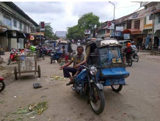 Gambar 6. Informan keempat (Ucok) saat melakukan pekerjaan tambahannya  sebagai montir, didepan rumahnya