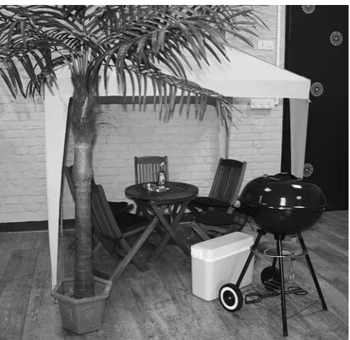Figure 1Play corner with party tent, garden furniture and a barbequein child sizes.