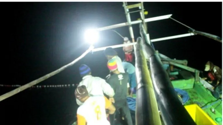 Gambar 2.1:  Nelayan Rawe sedang menarik jaring dari laut dengan  penerangan lampu 