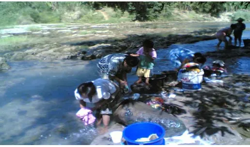Gambar 3. Ibu-ibu pemecah batu yang sedang menjalankan peran ibu rumah tangga dengan mencuci pakaian keluarga.