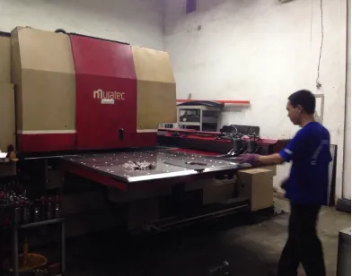Gambar 3. Pekerja sedang bekerja memotong plat menggunakan mesin CNC 