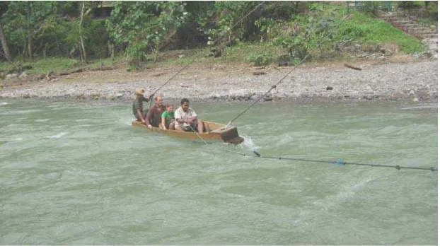 Gambar 1. Perahu Penyebrangan : Turis asing dan salah seorang ranger‘tegang’ saat menaiki perahu yang di tarik menggunakan tali tambang yang di kaitkan ditiang yang di hubungkan di pohon