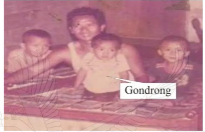 Gambar 1. Dalam pangkuan ayahnya, Gondrong yang masih balita bersama saudara-saudaranya yang lain dikenalkan langsung dengan alat musik dan bunyi gender (koleksi pribadi Gondrong Gunarto)