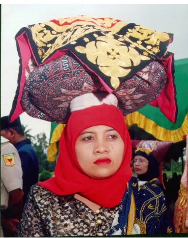 Gambar 11:   Kaum  ibu, membawa juadah yang ditutup dengan tudung saji ke tempat  upacara di Pagaruyung (2002) 