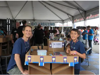 Figure 3-3. Ethan and Quin Etnyre at Qtecknow’s display, New York Maker Faire, 2013. Photo courtesy of Karen Mikuni
