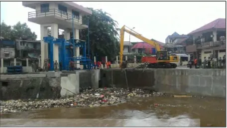 Gambar 1.1 : Sibuknya Petugas Bersihkan Sampah di Pintu Air Manggarai  (sumber: Liputan 6.com) 