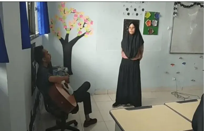 Gambar 8. Guru menggunakan gitar sebagai iringan siswa yang sedang bernyanyi (Doc. 