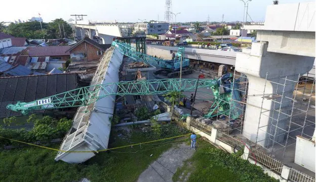 Gambar  1.  Dua  alat  berat  yang mengangkut  girder  (steel  box)  pembangunan  Light  Rail  Transit  (LRT)  terjatuh  menimpa  rumah  di  zona  5  pembangunan  LRT  Palembang,  Sumatera  Selatan,  Selasa  (1/8/2017)