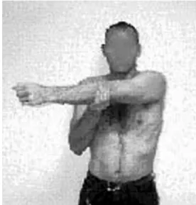 Gambar 1 .  peregangan posterior bahu. Berdiri dengan punggung bersandar di  dinding. Pegang lengan yang terpengaruh secara langsung