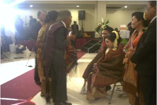 Gambar  2:  pengantin  di  depan  pelaminan  (bawah  panggung  auditorium  UNY) bersama orang tuanya menerima nasihat dari keluarga 