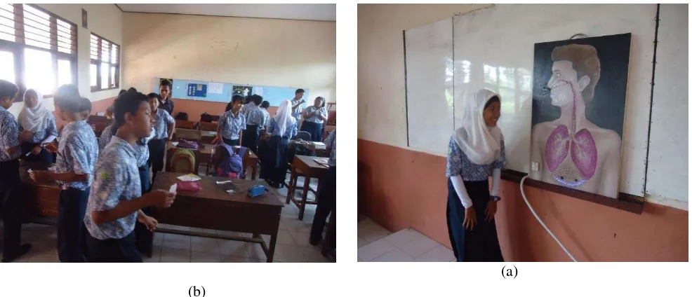 Gambar 1. (a) guru menyampaikan materi dengan menggunakan media bagan elektrik (b) siswa          memperhatikan penjelasan guru 