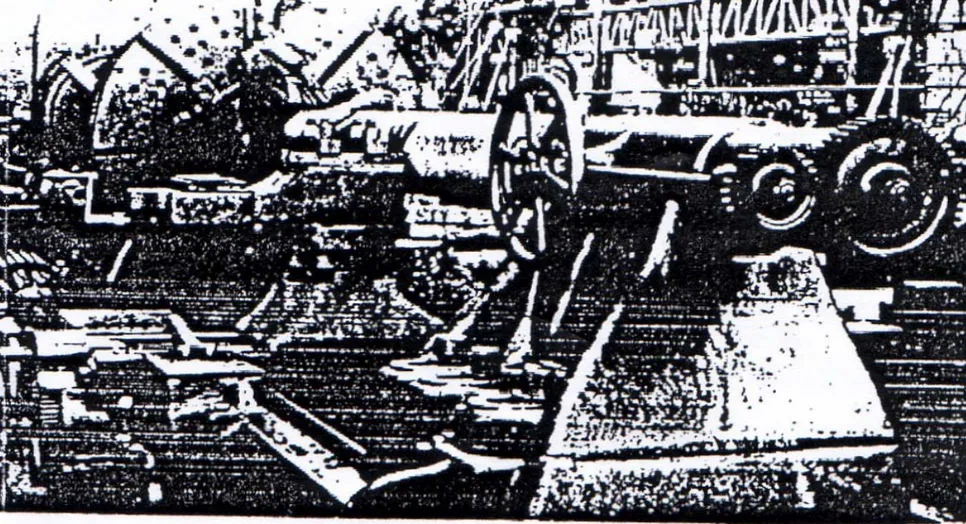 Gambar 18.1. Sebuah pembubut mesin awal abad kedua puluh yang digerakkan oleh Sabuk. Orang yang berdiri dalam lubang landasan sedang memeriksa diameter.