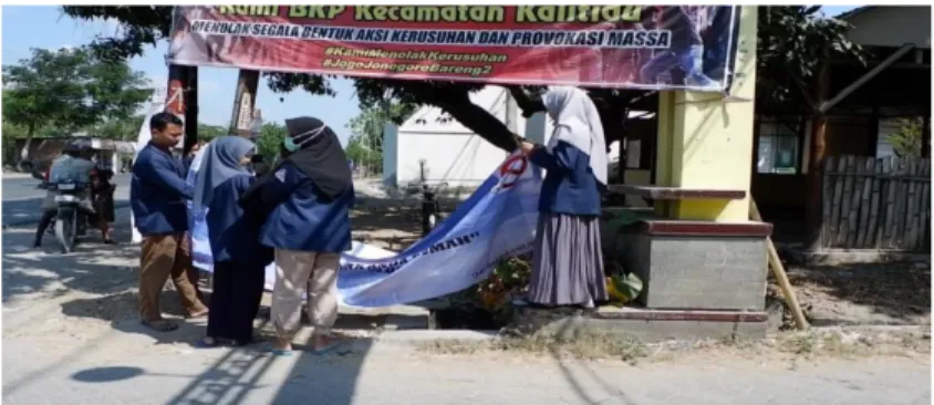 Gambar 3. Proses pemasangan banner di Gapura Desa Mayangrejo 